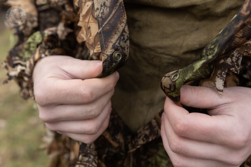 Maskovací oblek sa zapína pomocou 5 plastových cvokov.